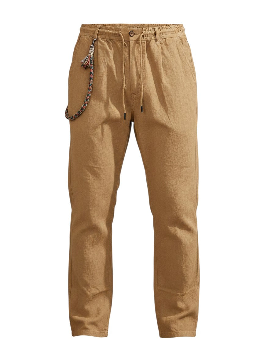 Pantalon casual Maison Bryzen beige en tissu fluide avec cordon de serrage, poches latérales et détail tressé.